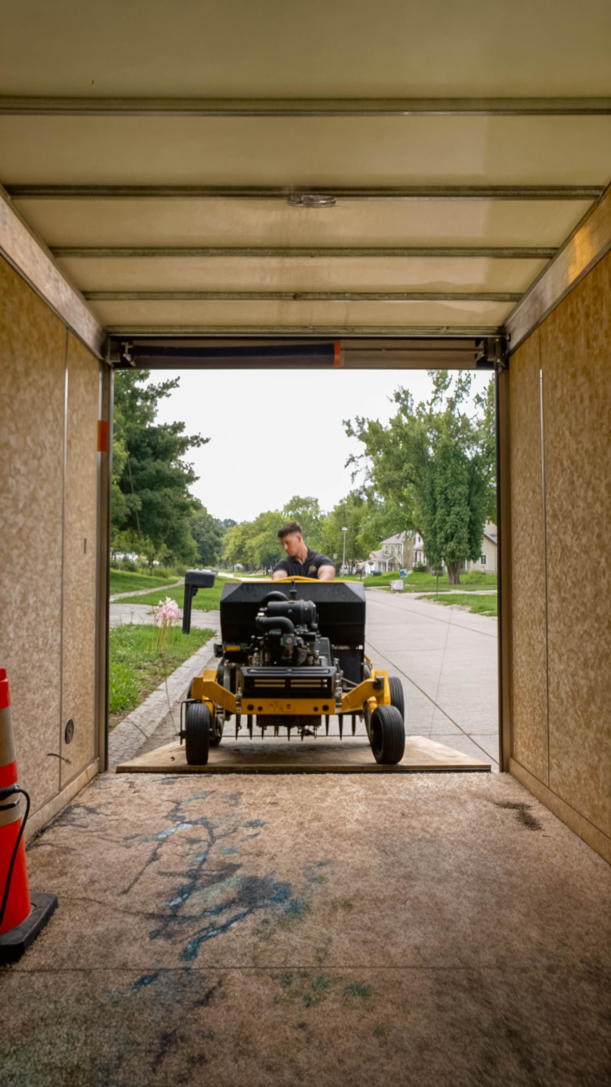 Heartland Grounds crew member unloading equipment from the trailer on a Coralville street